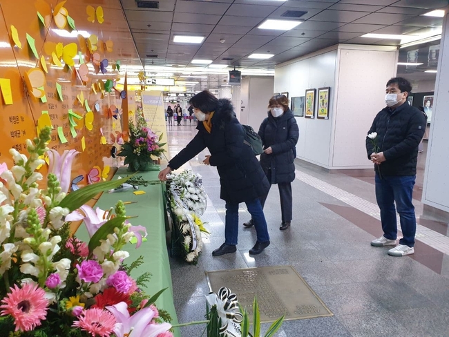 대구지하철 참사 18주기를 맞아 정의당 대구시당 관계자들이 주앙로 역에서 헌화 하고 있다 .