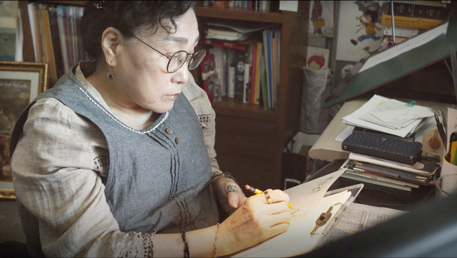 만화가 이해경 화백이 화실에서 만화 원고를 그리고 있다