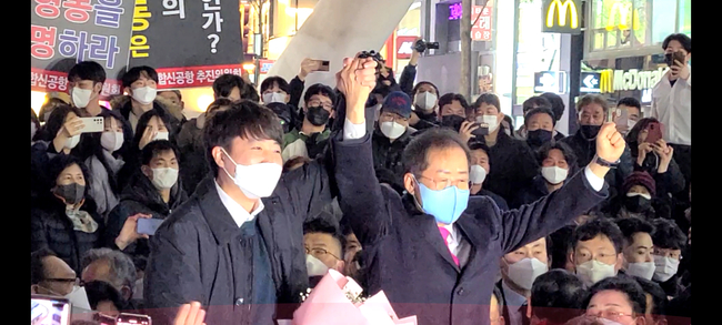 대구 동성로에서 이준석 국민의힘 대표와 홍준표 고문이 손을 맞잡아 치켜들고 지지자들에게 화답하고 있다 .