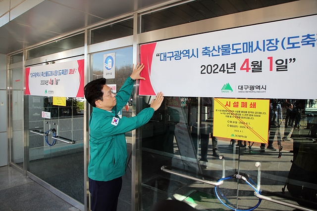안중곤 대구시 경제국장이 1일 대구시 축산물도매시장 시설폐쇄 안내를 위한 현수막을 걸고 있다.